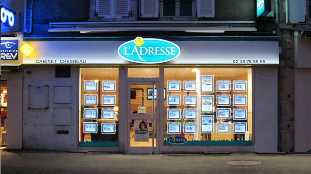 Porte-affiches LED sur la vitrine d'une agence immobilière à Paris